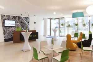un vestíbulo con mesas blancas y sillas verdes en IG City Apartments Danube Lodge, en Viena
