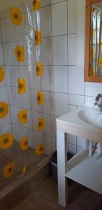 un bagno con lavandino e fiori gialli sul muro di Mango Garden Cottages a Tanetane
