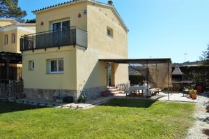 a house with a balcony on top of a yard at Villa Babette in Vidreres