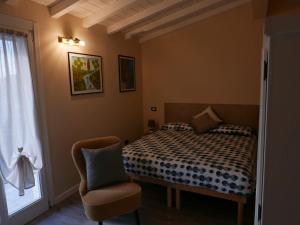 a bedroom with a bed and a chair and a window at Casa Camilla in Milan