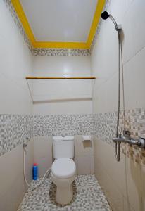 a bathroom with a white toilet in a room at Zamzam anjani villa in Praya