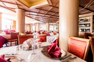 um restaurante com uma mesa com guardanapos vermelhos em Hotel Cristallo em Sestriere