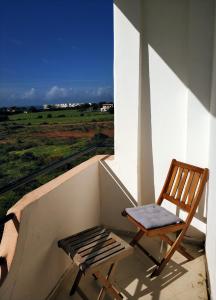 a chair sitting on a porch with a view of a field at Achakar Hills , Piscine , Vue & Accès à la mer in Tangier