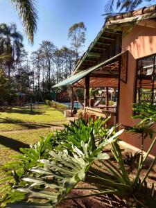 a group of plants in front of a building at Pousada Chácara Rama in Botucatu