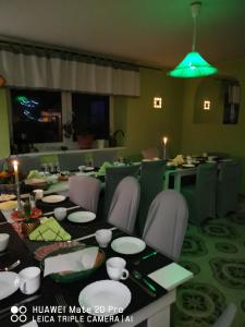 a dining room with a table and chairs and a green light at Agroturystyka in Uniejow