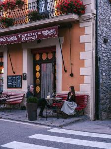 una mujer sentada en una mesa fuera de un restaurante en Casa Leonardo, en Senterada