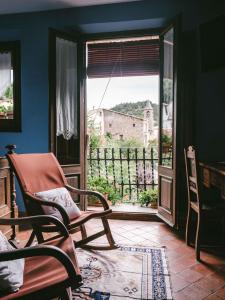 um quarto com uma cadeira de baloiço e uma janela em Casa Leonardo em Senterada