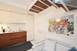 kuchnia z białymi szafkami i obrazem na ścianie w obiekcie Gio Suite Amalfi w Amalfi