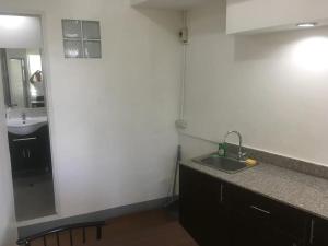 a small kitchen with a sink and a mirror at 500Mbps Wi-Fi 2-Story Apartments in Cebu City +45 photos