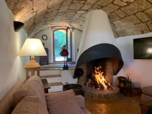 sala de estar con chimenea y sofá en Cal Secretari, en Rellinars