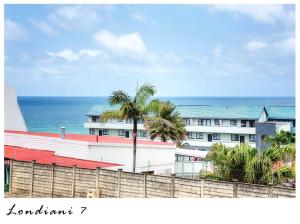 un bâtiment avec un palmier en face de l'océan dans l'établissement 7 Londiani, à Margate