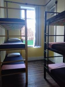 a room with three bunk beds and a window at Lapa Casa Hostel in Rio de Janeiro