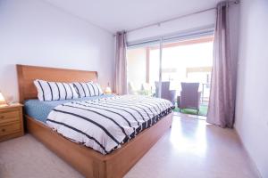 Luxury Beach Apartment - Romantic Weekend Getaway في Agadir nʼ Aït Sa: غرفة نوم بسرير ونافذة كبيرة