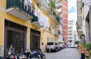 un grupo de motocicletas estacionadas en una calle al lado de los edificios en Gloria's Home - Vomero en Nápoles