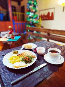 einen Tisch mit Tellern und einer Tasse Kaffee in der Unterkunft DRIMIN by sunrise caravan - Family boutique guesthouse and hostel in Taschkent