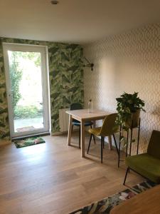 Zimmer mit einem Tisch, Stühlen und einem Fenster in der Unterkunft Appart Jungle in Clermont-Ferrand