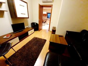 ein Wohnzimmer mit einem Sofa und einem Tisch in der Unterkunft GrandVille Apartments in Bukarest