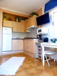 uma cozinha com um frigorífico branco e uma mesa em Alojamiento El Altet Playa em El Altet
