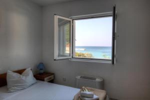 a bedroom with a window with a view of the ocean at Accommodation Family Magazin in Žuljana