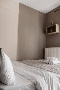 a bedroom with a bed with white sheets and towels at Zefiron City View in Thessaloniki