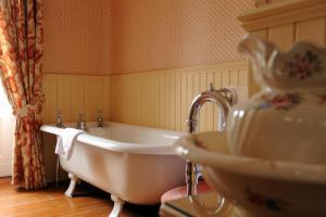 a bathroom with a white tub and a sink at Ballathie House Hotel in Perth