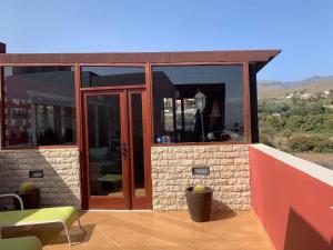 a house with glass doors on a patio at Daniella in Ingenio