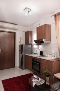 a kitchen with wooden cabinets and a stainless steel refrigerator at Egnatia Flat in Thessaloniki
