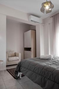 テッサロニキにあるEgnatia Flatのベッドルーム1室(ベッド1台、椅子付)