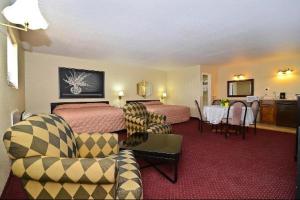 um quarto de hotel com duas camas e uma mesa e cadeiras em Americas Best Value Inn Refugio em Refugio
