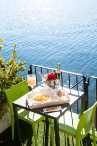 einen Tisch mit 2 Stühlen und einen Tisch mit Weingläsern in der Unterkunft The Pier On The Lake in Marone