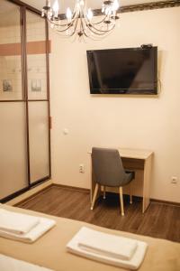 a room with a table and a chair and a television at Traveler's Mini-Hotel in Tyumen