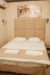 チュメニにあるTraveler's Mini-Hotelのベッド1台(白いタオル2枚付)