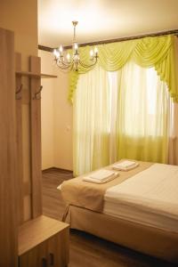 a bedroom with two beds and a chandelier and a window at Traveler's Mini-Hotel in Tyumen
