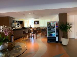 un ristorante con bar e frigorifero per bevande di Barretos Park Hotel - Condo Hotel a Barretos