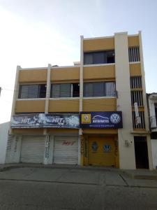 um edifício amarelo com um sinal na lateral em HOTEL en MONTERIA CITY em Montería