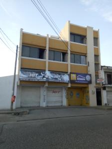 un edificio amarillo con un cartel en el costado en HOTEL en MONTERIA CITY, en Montería