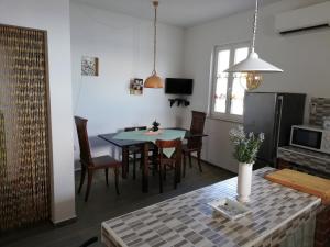 una cucina e una sala da pranzo con tavolo e sedie di Villa Frane 101 a Beli (Caisole)