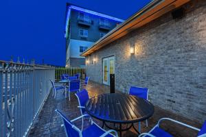 a patio with a table and chairs and a building at Holiday Inn Express Hotel and Suites Jenks by IHG in Jenks