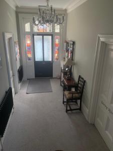 a hallway with a black door and a table and chairs at Hotel 50 in Bournemouth