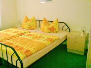 - une chambre avec 2 lits dotés de draps jaunes et oranges dans l'établissement Ferienwohnung Herpich, à Ehrenberg