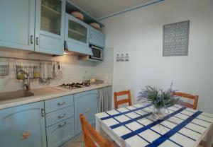 una cocina con armarios azules y una mesa con un jarrón. en Casa Vacanza Sardegna, en Valledoria