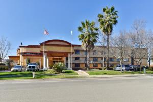a large building with palm trees in front of it at Holiday Inn Rancho Cordova - Northeast Sacramento, an IHG Hotel in Rancho Cordova