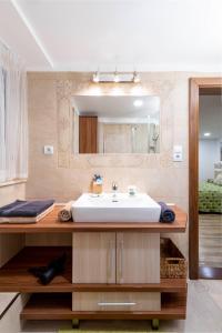 a bathroom with a sink and a mirror at Moon Stone Residence Pag in Pag