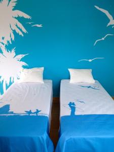 a room with two beds with birds on the wall at Arrifana Guest House in Aljezur