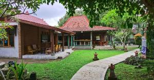 a house with a green yard in front of it at Puri Pangeran Hotel in Yogyakarta