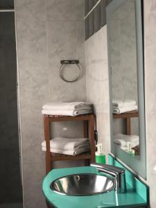 y baño con lavabo, espejo y toallas. en Apartamento Gran Comedias en Málaga