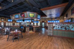 a restaurant with tables and chairs and televisions at Holiday Inn Midland by IHG in Midland