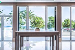 a table with a potted plant on it in a room with windows at Crowne Plaza Limassol by IHG in Limassol