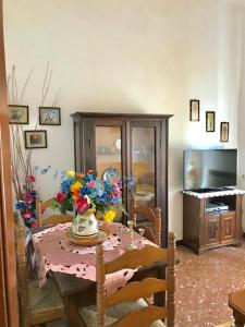 una mesa de comedor con un jarrón de flores. en Appartamento Aurora en La Spezia