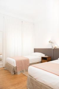 sypialnia z 2 łóżkami i oknem w obiekcie Flattered to be in Lisboa w Lizbonie